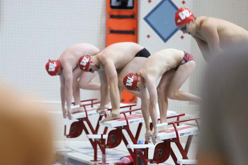a group of men in swim suits starting blocks