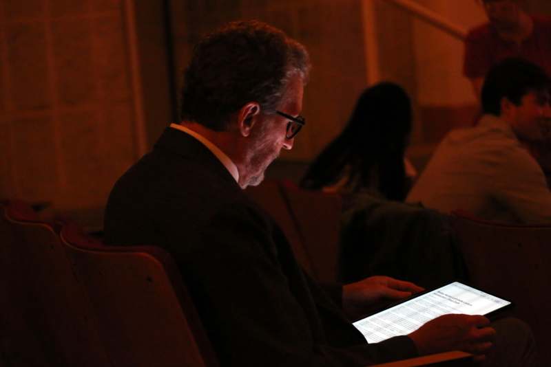 a man sitting in a chair using a tablet
