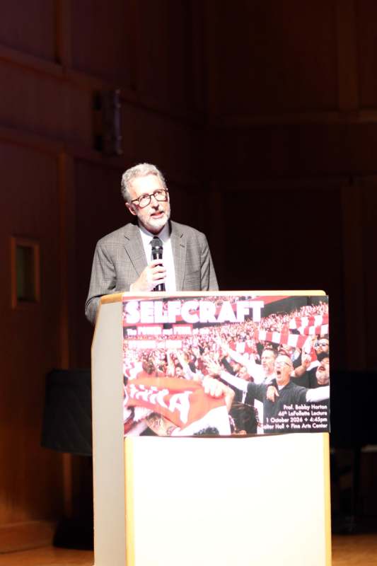 a man standing at a podium with a microphone