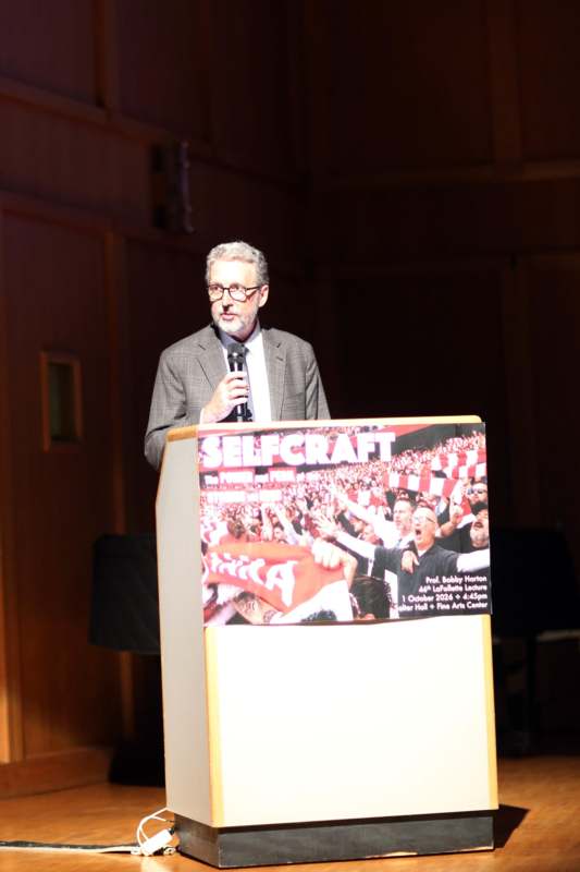 a man standing at a podium speaking into a microphone