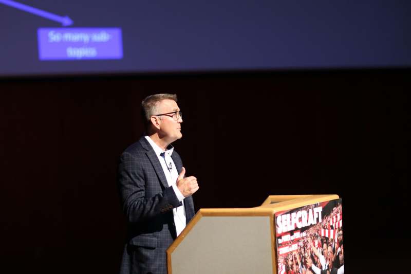 a man giving a thumbs up at a podium