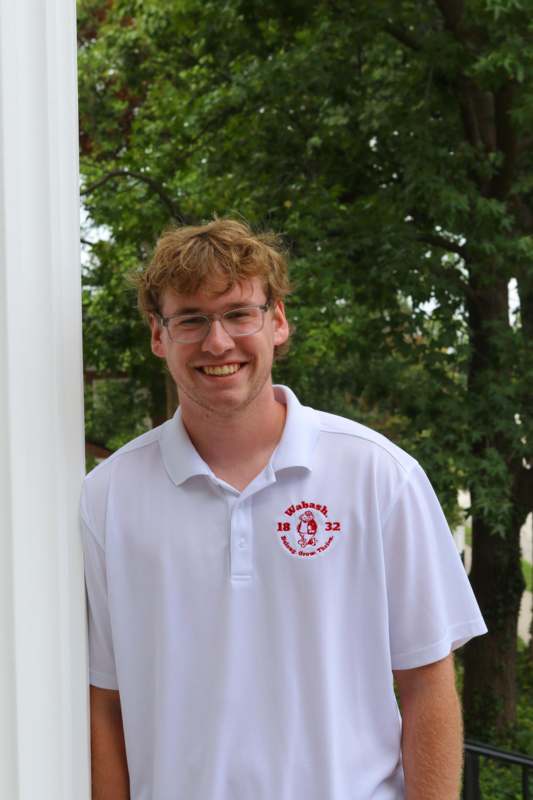 a man wearing glasses and a white polo shirt