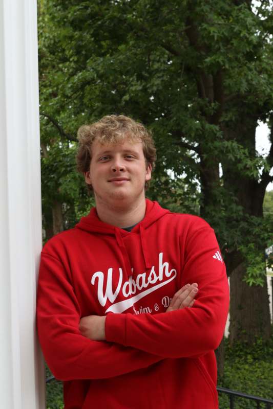 a man standing next to a pillar