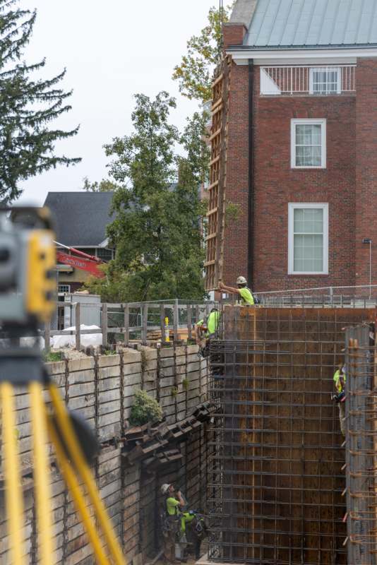 a construction site with a building and a man standing on the side