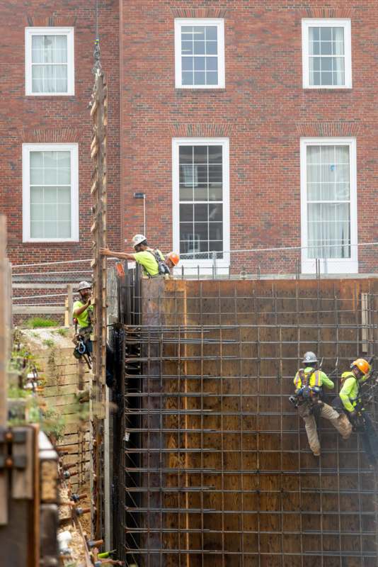 a group of construction workers climbing up a wall