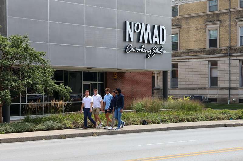 a group of people walking on the sidewalk