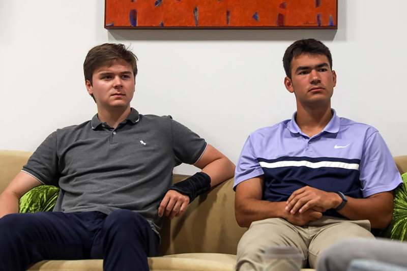 two men sitting on a couch