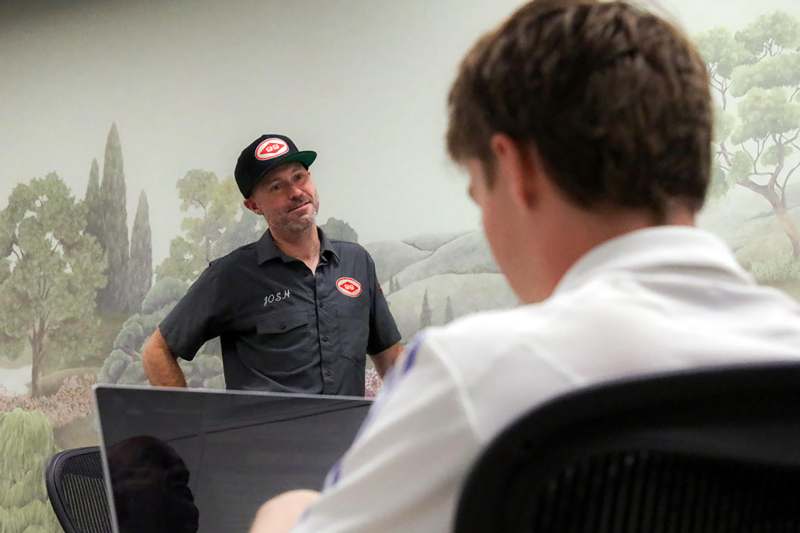 a man in a black hat talking to a man in a black hat