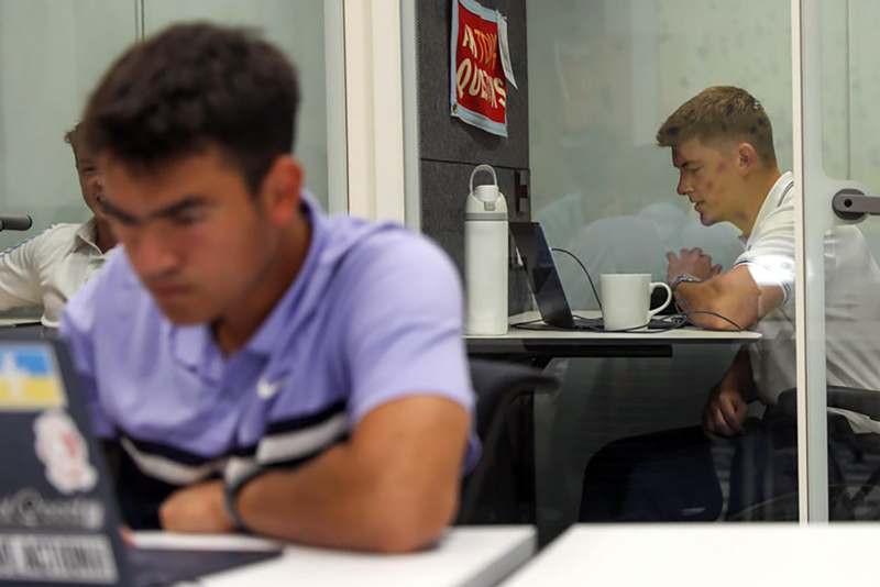 a man sitting at a desk with his laptop