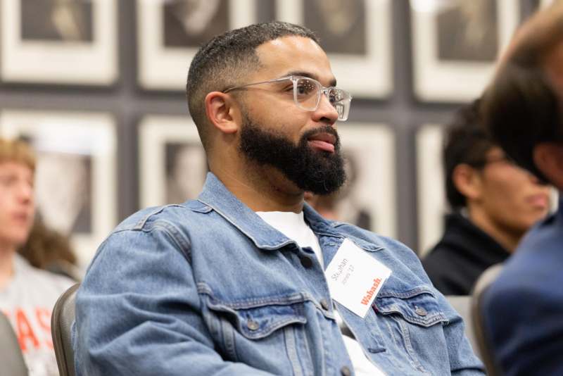 a man wearing glasses and a denim jacket