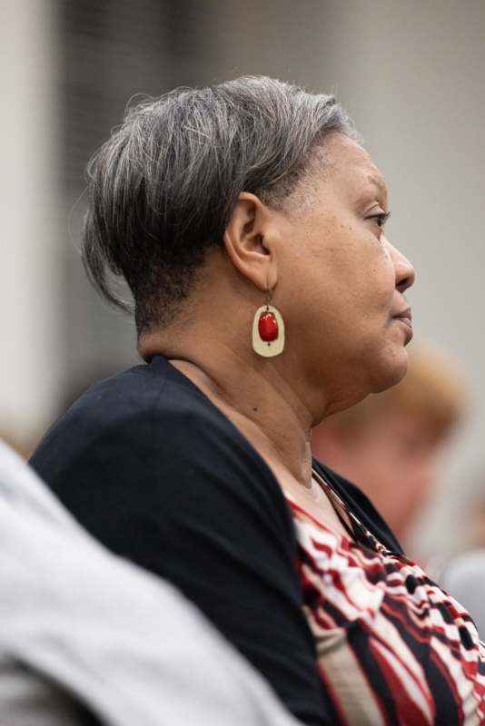a woman with short hair wearing a red and white earrings