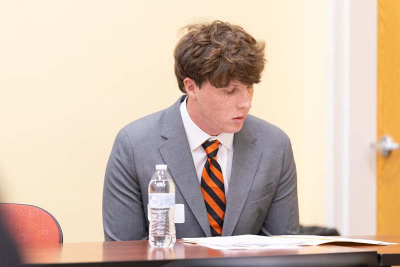 a man in a suit and tie sitting at a desk