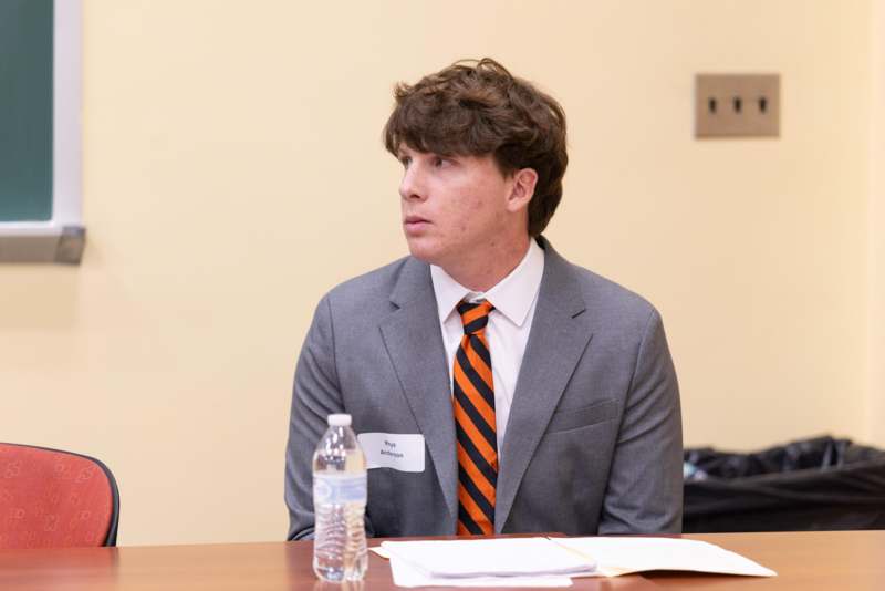 a man in a suit and tie sitting at a table