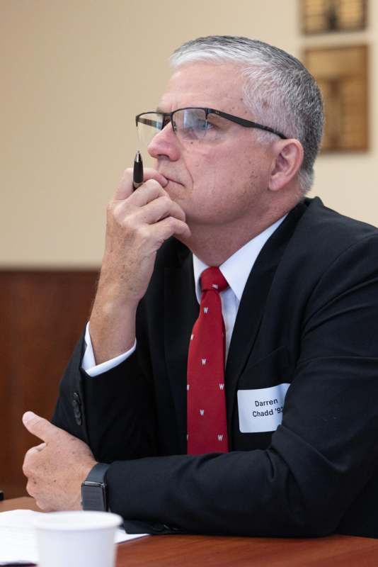 a man in a suit and tie holding a pen