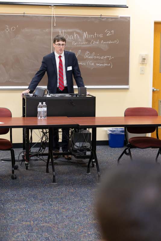a man standing in front of a blackboard