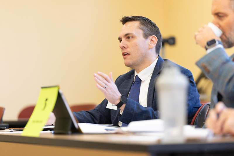 a man in a suit talking to another man