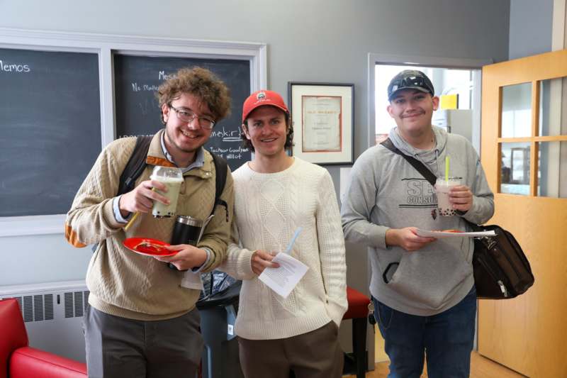 a group of men smiling and holding drinks