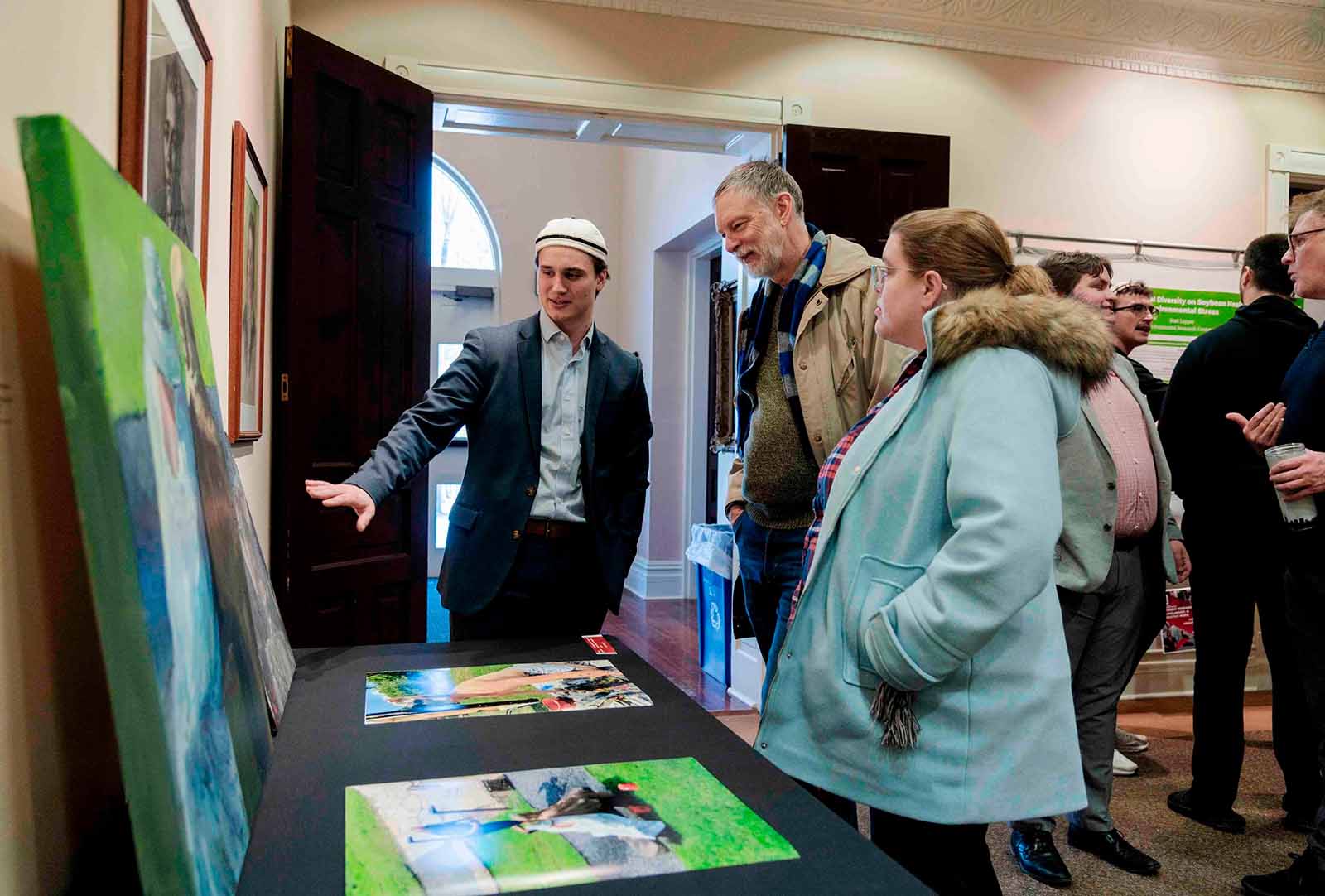 a group of people looking at a table with pictures